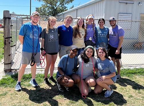 Group of smiling volunteers from Howard Payne University posing for a photo on a sunny day. | HPU